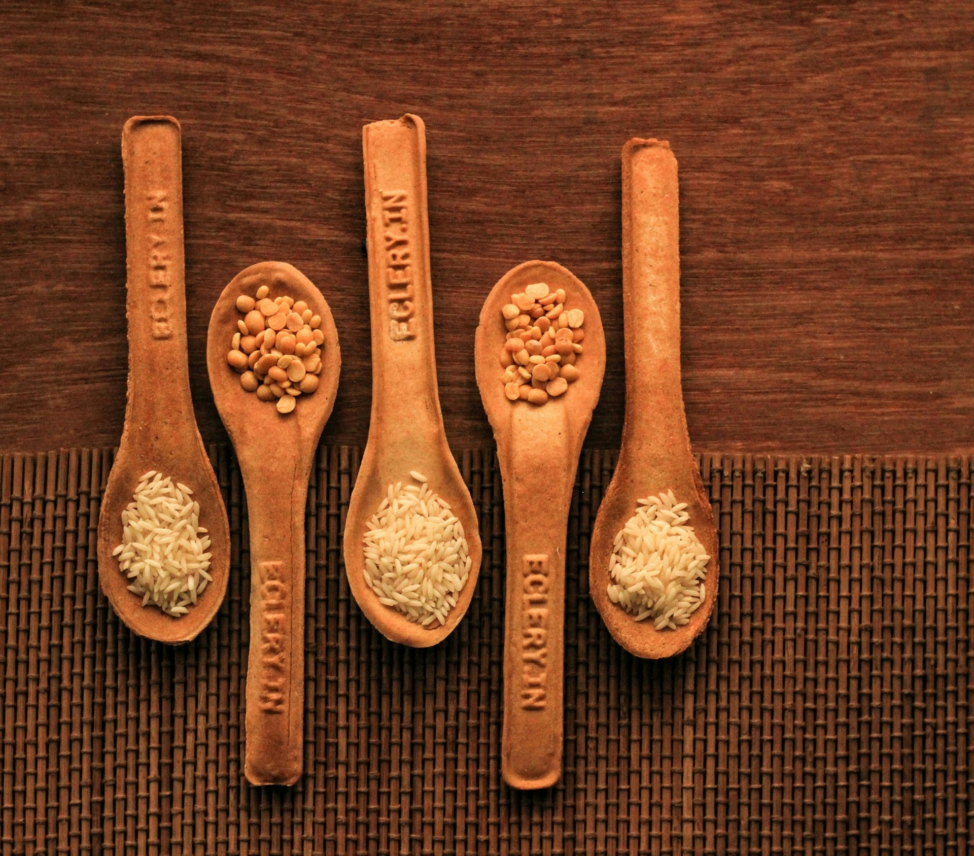 Four wooden spoons with different types of food on them
